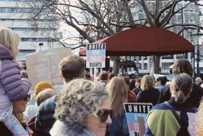 Group of people in front of stand holding signs
